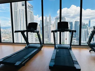 a gym with two treadying machines in front of a window at Majestic Suites klcc By Falak in Kuala Lumpur