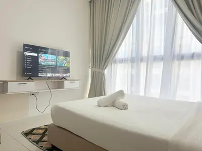 a bedroom with a bed and a flat screen tv at Majestic Suites klcc By Falak in Kuala Lumpur