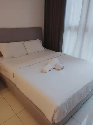 a white bed with a towel on it in a room at Kuala Lumpur Majestic Suites KLCC in Kuala Lumpur