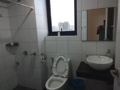 a bathroom with a toilet and a sink and a window at Kuala Lumpur Chambers Suites KLCC in Kuala Lumpur