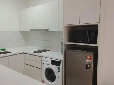 a kitchen with a washing machine and a microwave at Kuala Lumpur Chambers Suites KLCC in Kuala Lumpur