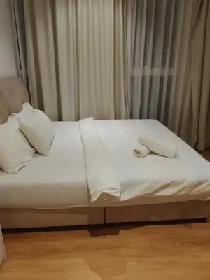a white bed with a stuffed animal laying on it at Quill Kuala Lumpur Suites KLCC in Kuala Lumpur