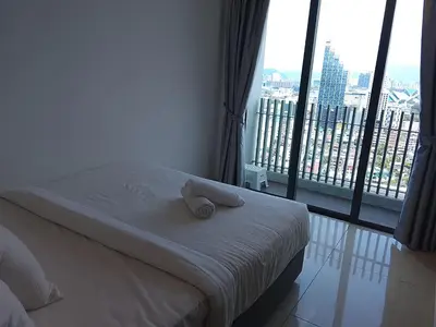 a bed with a towel on it in a room with a window at The Luxe Suites Colony Sky Pools in Kuala Lumpur