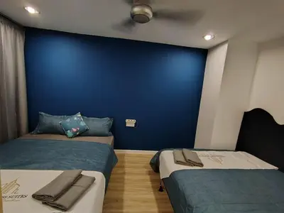 two beds in a room with a blue wall at Fahrenheit 88 4R in Kuala Lumpur