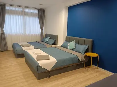 two beds in a room with a blue wall at Fahrenheit 88 4R in Kuala Lumpur