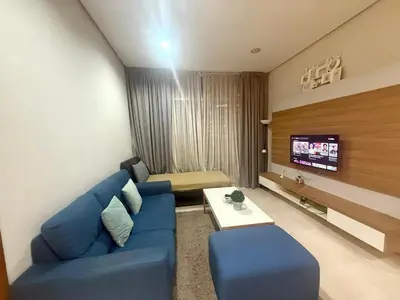 a living room with a blue couch and a tv at Soho Suites KLCC by MIMI in Kuala Lumpur