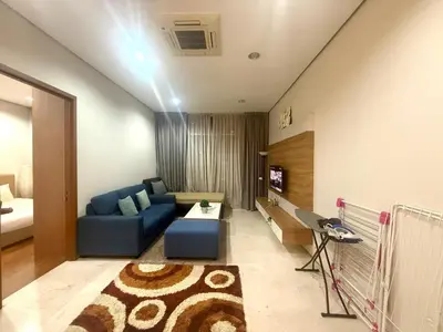 a living room with a blue couch and a tv at Soho Suites KLCC by MIMI in Kuala Lumpur