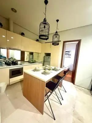 a kitchen with a table with chairs and two cages at Soho Suites Klcc By Bukit Bintang in Kuala Lumpur