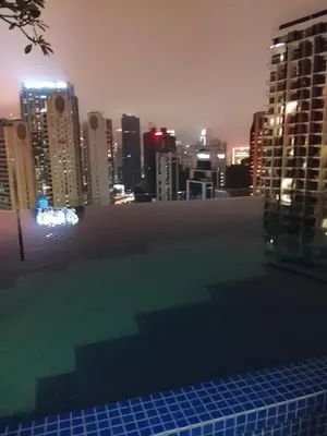 a swimming pool with a view of a city at night at Majestic Suites Quill Mall Apartment in Kuala Lumpur