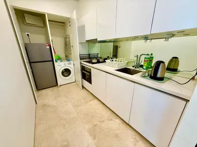 a kitchen with a refrigerator and a washing machine at vortex suites apatment by sapporo in Kuala Lumpur