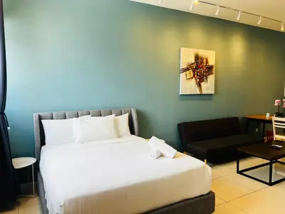 a bedroom with a large white bed and a couch at Chambers Suites By Grands in Kuala Lumpur