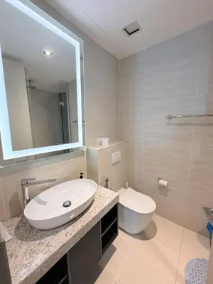 a bathroom with a white sink and a toilet at Star Residence klcc by Aqua in Kuala Lumpur
