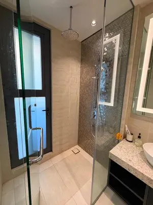 a bathroom with a glass shower and a sink at Star Residence klcc by Aqua in Kuala Lumpur