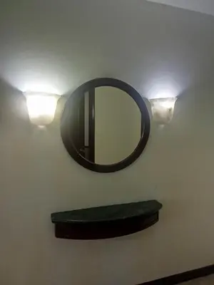 a mirror on a wall with a shelf and lights at Times square Suites at Time Square KL in Kuala Lumpur