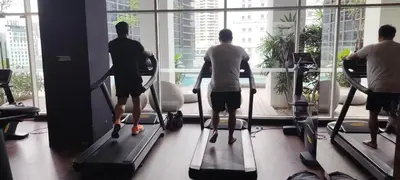 a group of people riding on tread machines in a gym at Sky Suites at Quill Residence Kuala Lumpur in Kuala Lumpur