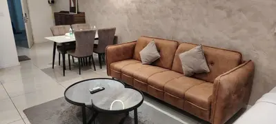 a living room with a brown couch and a table at Sky Suites at Quill Residence Kuala Lumpur in Kuala Lumpur