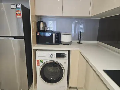 a kitchen with a washing machine and a microwave at Spacious Stylish Suite at Quill Resi KLCC 2Bed7Pax in Kuala Lumpur