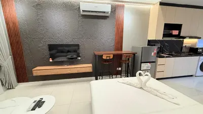 a living room with a tv and a kitchen at Majestic Sky Deck Suites in Kuala Lumpur