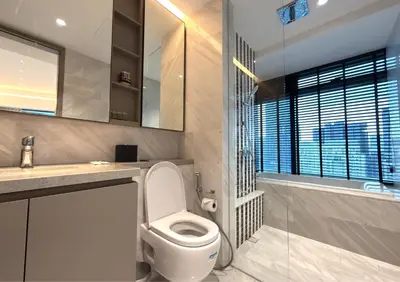 a bathroom with a toilet and a sink and a mirror at LUXURA SUITE's E A T O N KLCC in Kuala Lumpur
