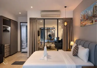 a bedroom with a bed and a living room at LUXURA SUITE's E A T O N KLCC in Kuala Lumpur