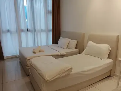 two beds and a couch in a room at Quill Luxury Suites KLCC in Kuala Lumpur