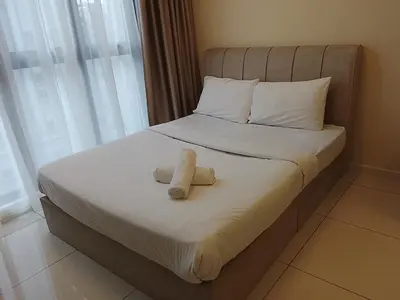 a bed with two towels on it with a window at Quill Luxury Suites KLCC in Kuala Lumpur