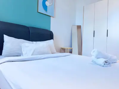 a white bed with a towel on top of it at Chambers Suites KLCC in Kuala Lumpur