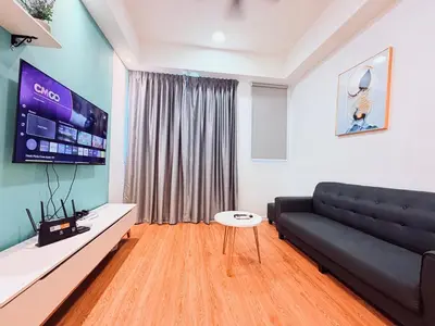 a living room with a black couch and a flat screen tv at Chambers Suites KLCC in Kuala Lumpur