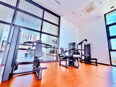 a gym with treadmills and exercise bikes in a room with windows at Chambers Suites KLCC in Kuala Lumpur