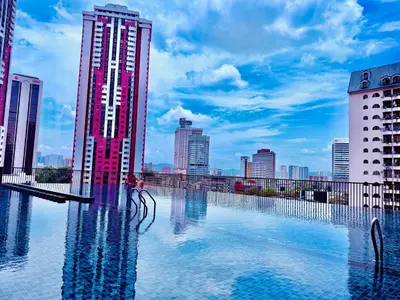 a woman is standing in a pool in a city at Chambers Suites KLCC in Kuala Lumpur