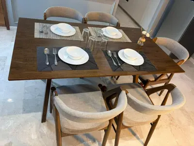 a wooden table with chairs and plates and silverware at SKY SUITES DMK KHADIZA GLOBAL BY KLcc in Kuala Lumpur