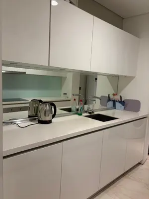 a white kitchen with white cabinets and a sink at SKY SUITES DMK KHADIZA GLOBAL BY KLcc in Kuala Lumpur