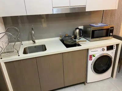 a kitchen with a microwave and a washing machine at Agile Heaven Luxury Suite bukit bintang in Kuala Lumpur