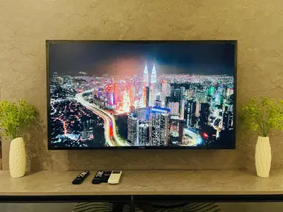 a television on a wall with a picture of a city at Agile Heaven Luxury Suite bukit bintang in Kuala Lumpur