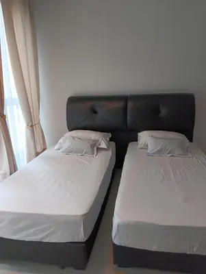 two twin beds in a room with a couch at Female Hostel Regalia Residence in Kuala Lumpur