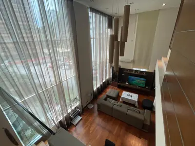 a living room with a couch and a tv and large windows at Kuala Lumpur luxury Duplex suits in Kuala Lumpur