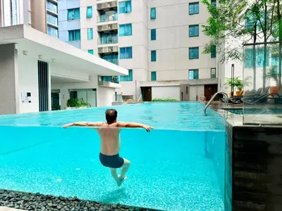 a man jumping into a swimming pool in a building at Chod ling pong by mercu summer KLCC in Kuala Lumpur
