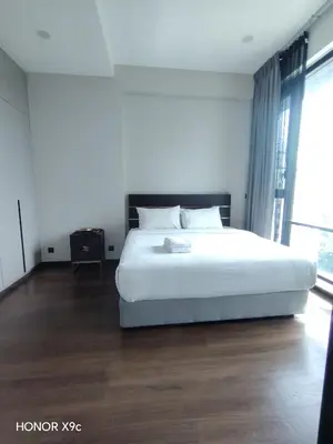 a bedroom with a white bed and a large window at Opus Residence KL118 By Millennium Suite in Kuala Lumpur