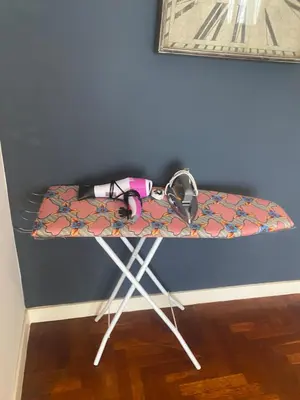 a ironing board with headphones on it next to a wall at Axora Sky Suites KLCC in Kuala Lumpur