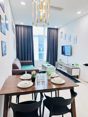 a living room with a wooden table and chairs at Axora Sky Suites KLCC in Kuala Lumpur