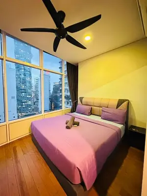 a bedroom with a large bed with a ceiling fan at Axora Sky Suites KLCC in Kuala Lumpur