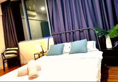 a bedroom with a white bed with blue pillows at STAR Hotel Apartment in Kuala Lumpur
