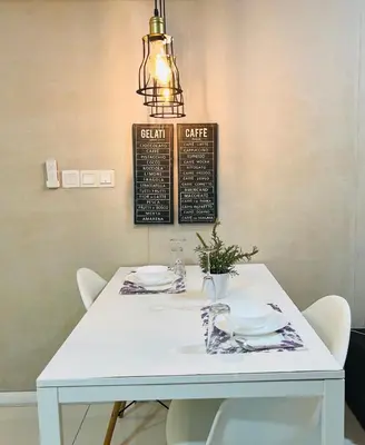 a white table with white chairs and a chandelier at Lux Retreat Home At Mercu Summer in Kuala Lumpur
