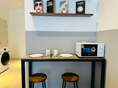 a table with two chairs and a microwave on it at Majestic Suites klcc By EQ in Kuala Lumpur
