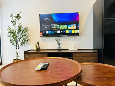 a remote control sitting on a wooden table with a tv at Majestic Suites klcc By EQ in Kuala Lumpur