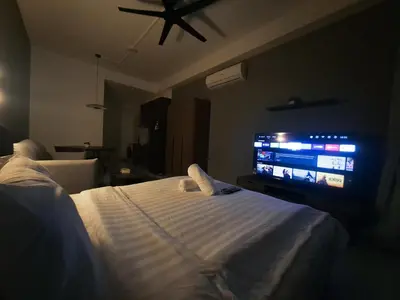 a bedroom with a bed and a flat screen tv at Grand Suites KLCC By Majestic Residence in Kuala Lumpur