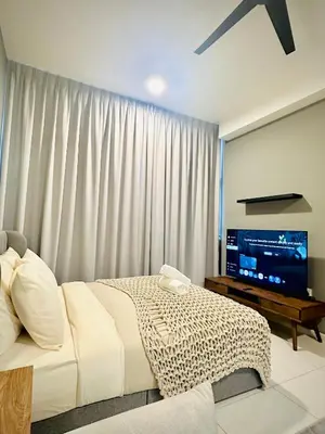 a bedroom with a bed and a flat screen tv at Grand Suites KLCC By Majestic Residence in Kuala Lumpur