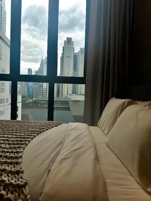 a bed in a room with a large window at Grand Suites KLCC By Majestic Residence in Kuala Lumpur
