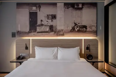 two pictures of a bed in a hotel room at The Kuala Lumpur Journal Hotel in Kuala Lumpur