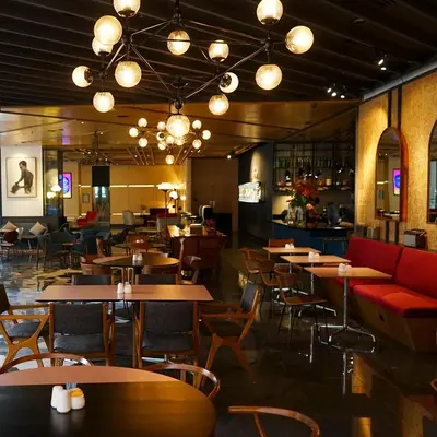a restaurant with tables and chairs and a bar at The Kuala Lumpur Journal Hotel in Kuala Lumpur